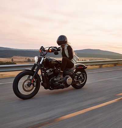 girl riding harley davidson, sunset in background